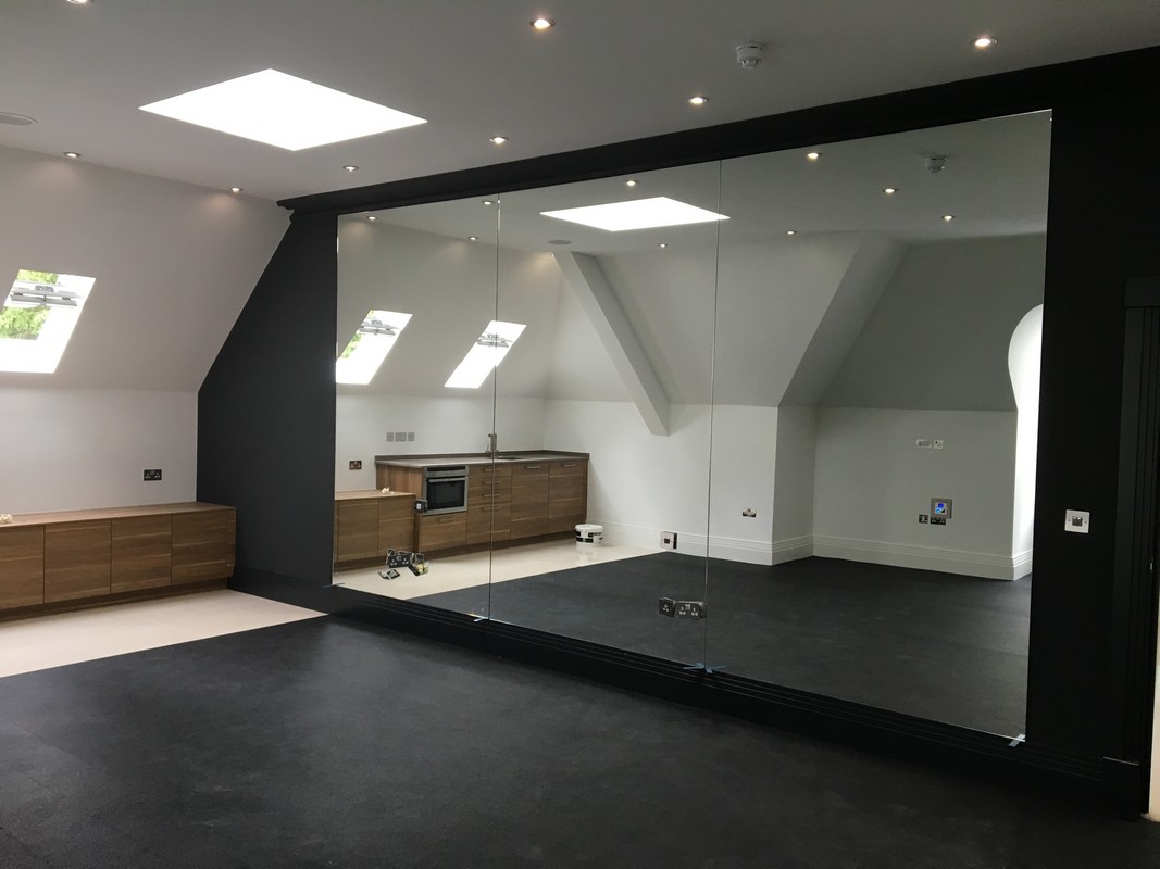 Frameless glass wall dividing loft conversion in Stratford